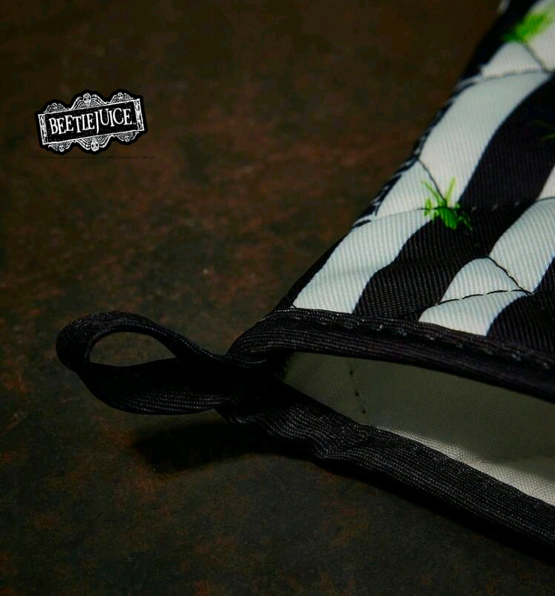 Black-and-white striped oven mitt with hanging loop and green bug accents