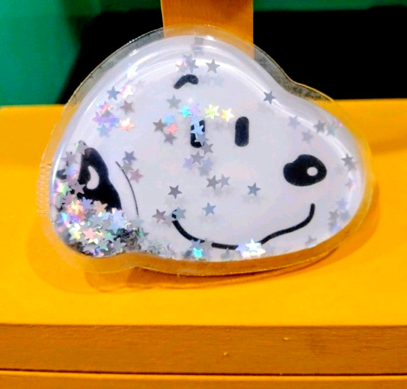 Heart-shaped Snoopy glitter phone grip with floating stars and sparkles