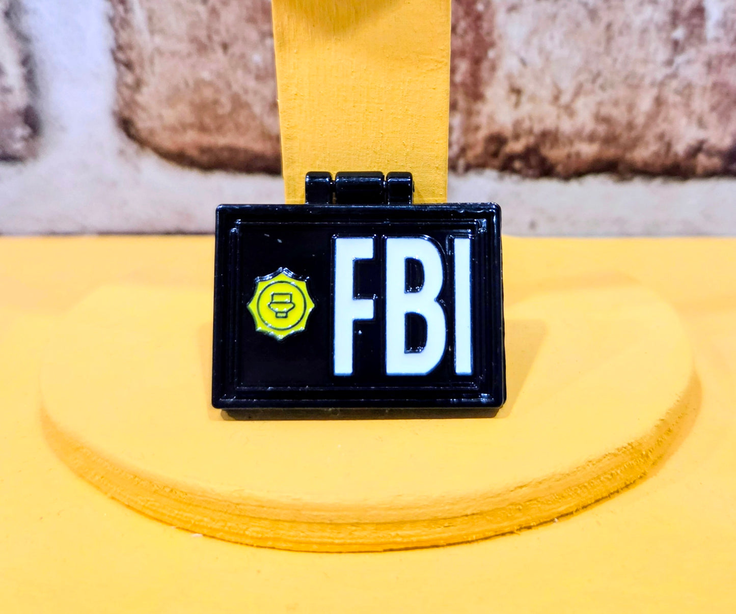 Rectangular enamel pin with “FBI” letters and badge icon on dark blue background.
