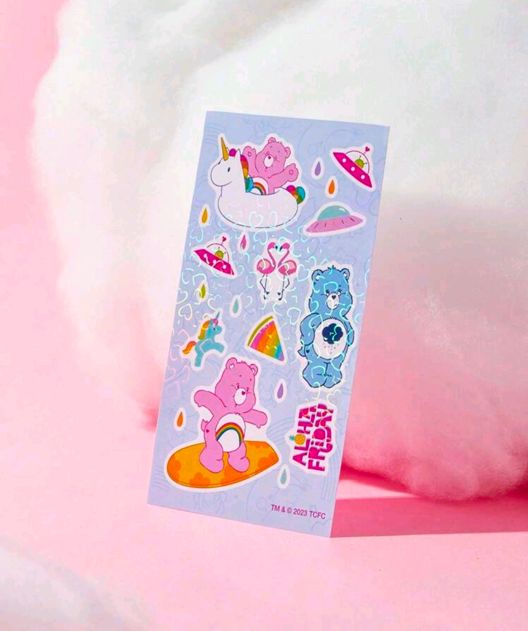Holographic sticker sheet with unicorn, rainbows, and Care Bears beside fruit shapes