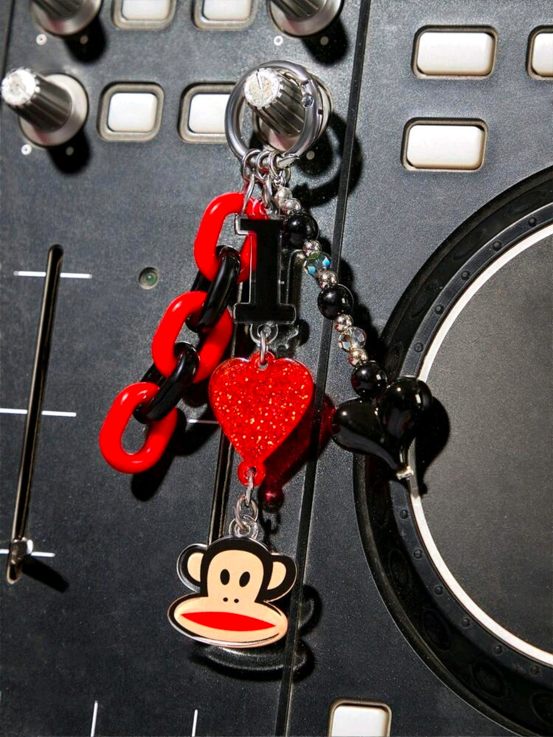 Red and black chain keychain with glitter heart and monkey face charm on a ring
