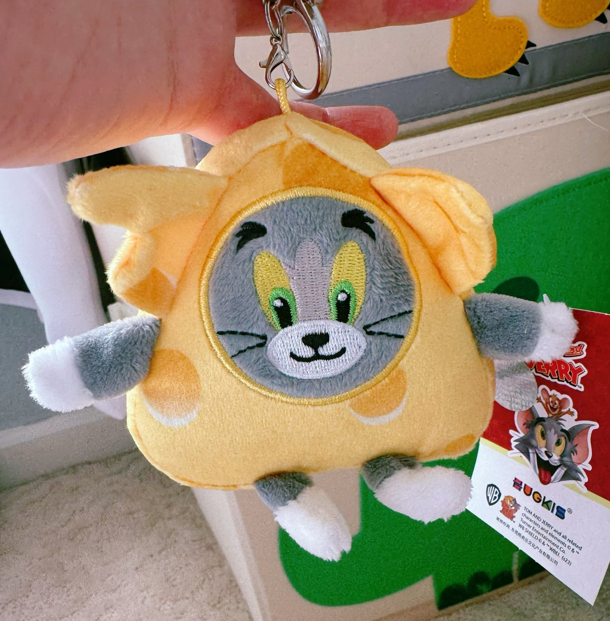 Cheese costume Tom cat plush keychain with metal ring, orange-yellow plush face close-up