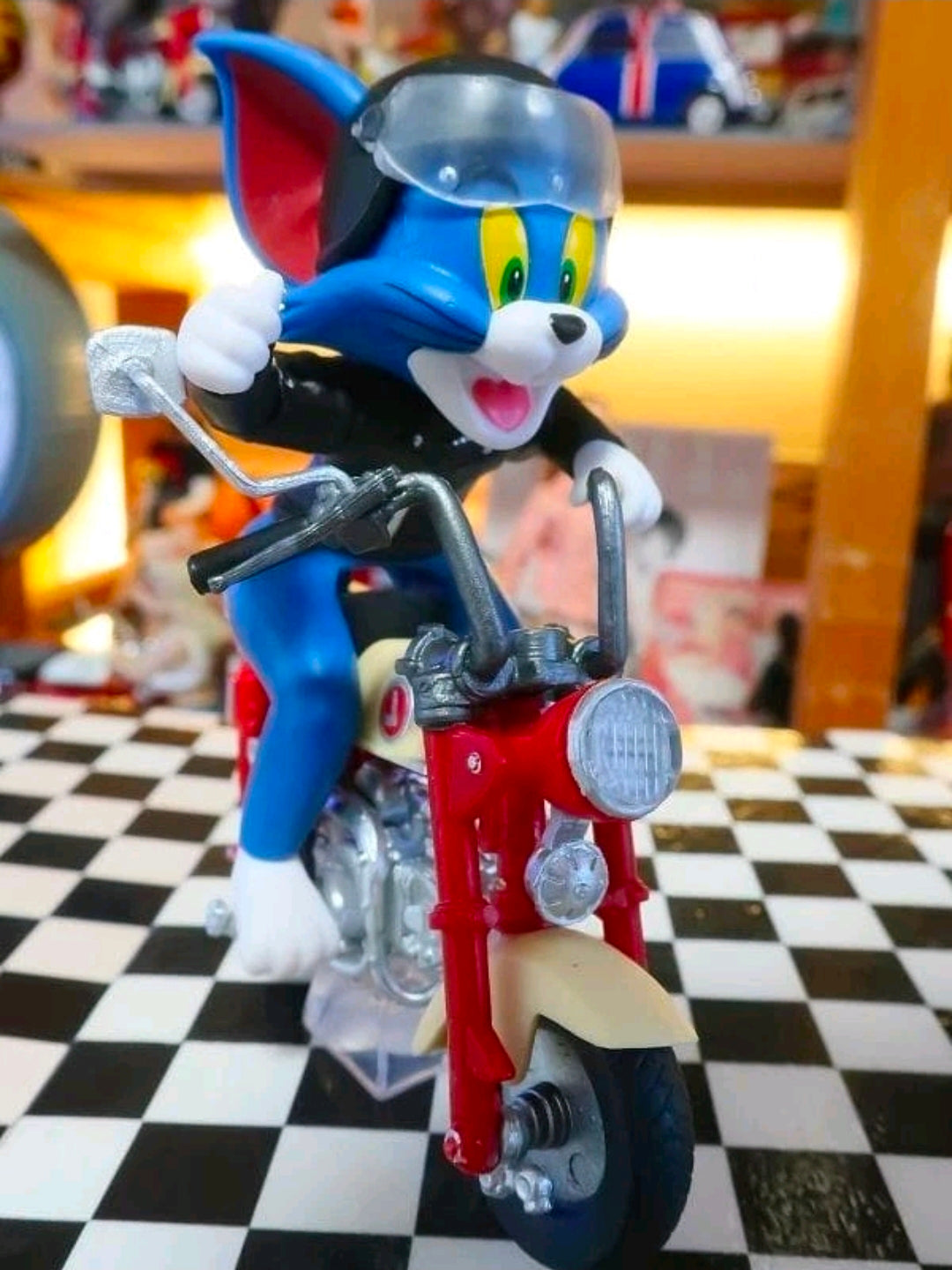 Biker Tom collectible figure in black helmet on red motorcycle, clear display stand