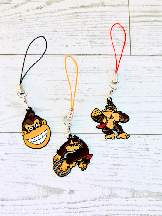 Set of 3 phone charm wrist straps with black, orange, and red cords and charms