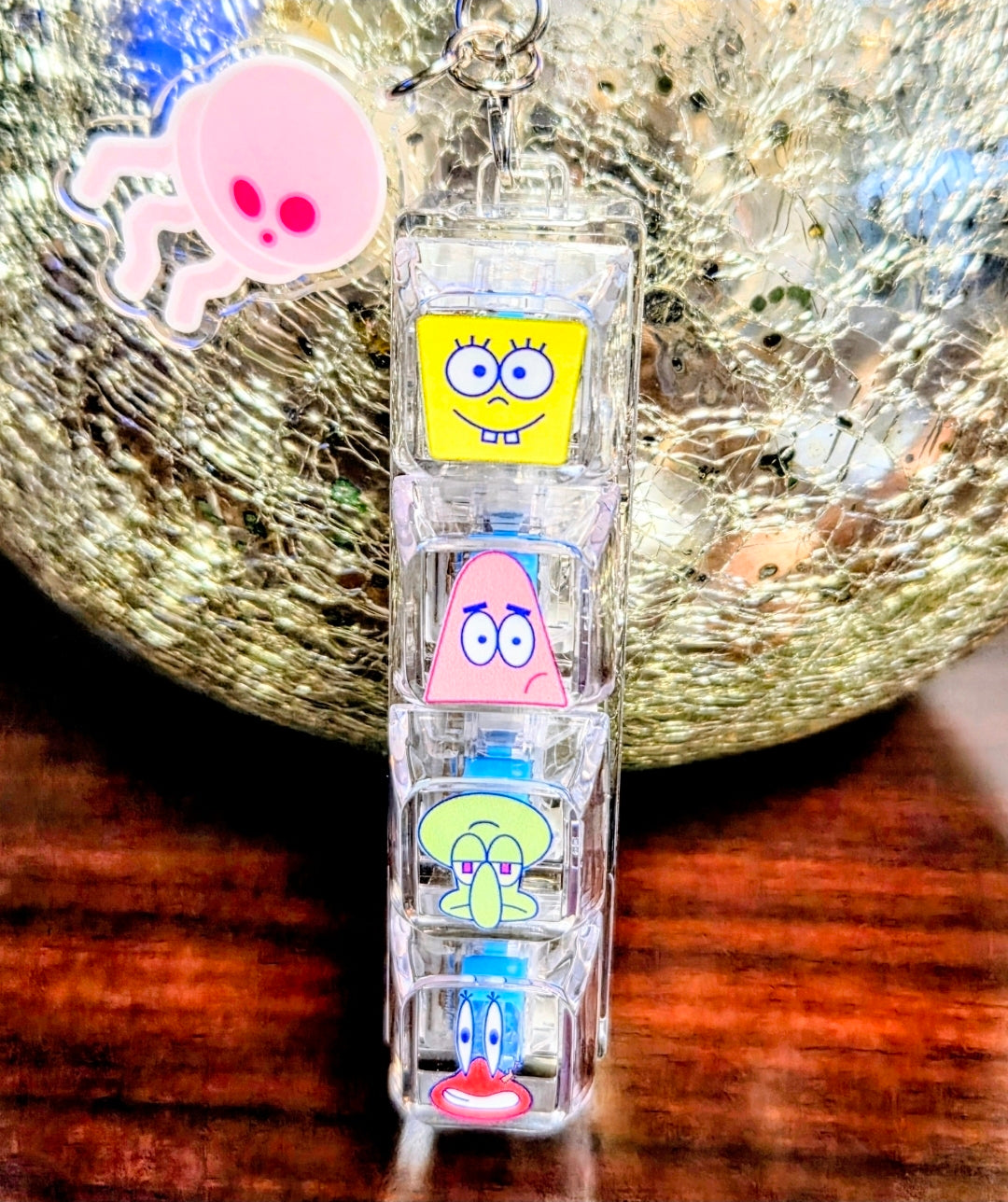 Clear acrylic keyboard fidget keychain centered, with four SpongeBob character panels and hand charm