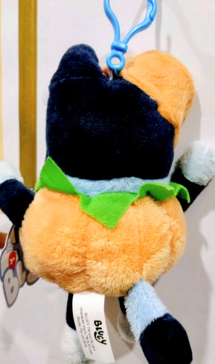 Black and orange Halloween plush keychain with green triangular scarf and hanging tag