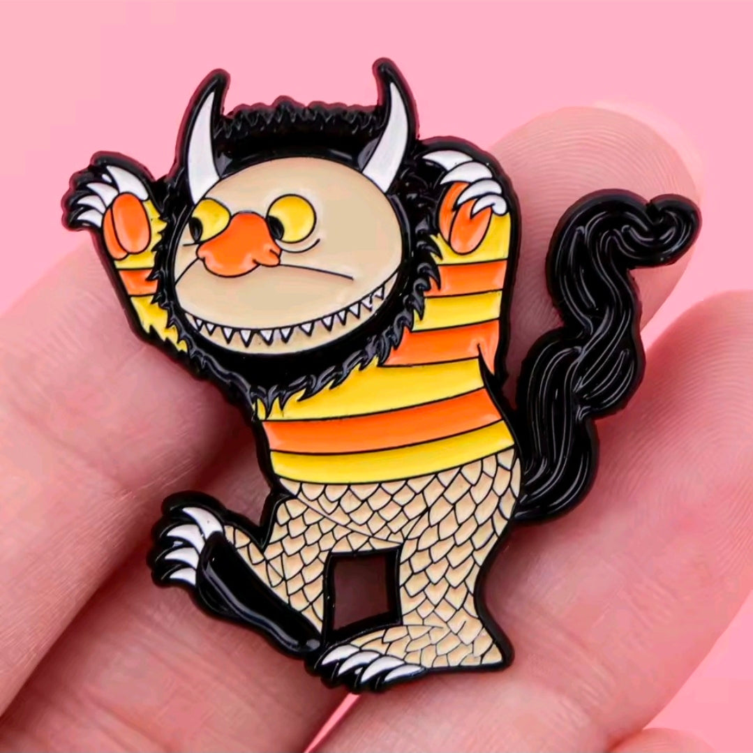 Enamel pin: wild thing creature with orange striped body, scaly belly, curled black hair