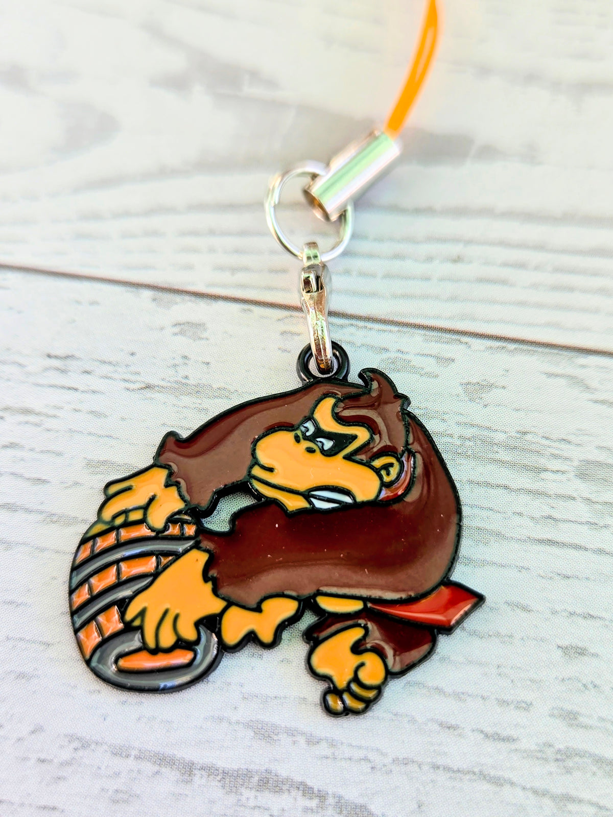 Orange cord phone charm wrist strap with Donkey Kong enamel character charm