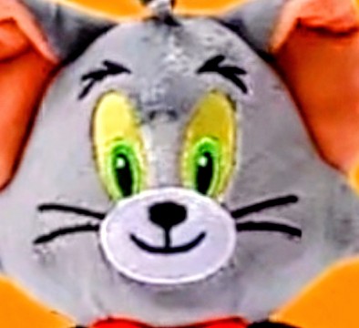 Grey plush cat keychain with bright green eyes, orange inner ears, smiling face