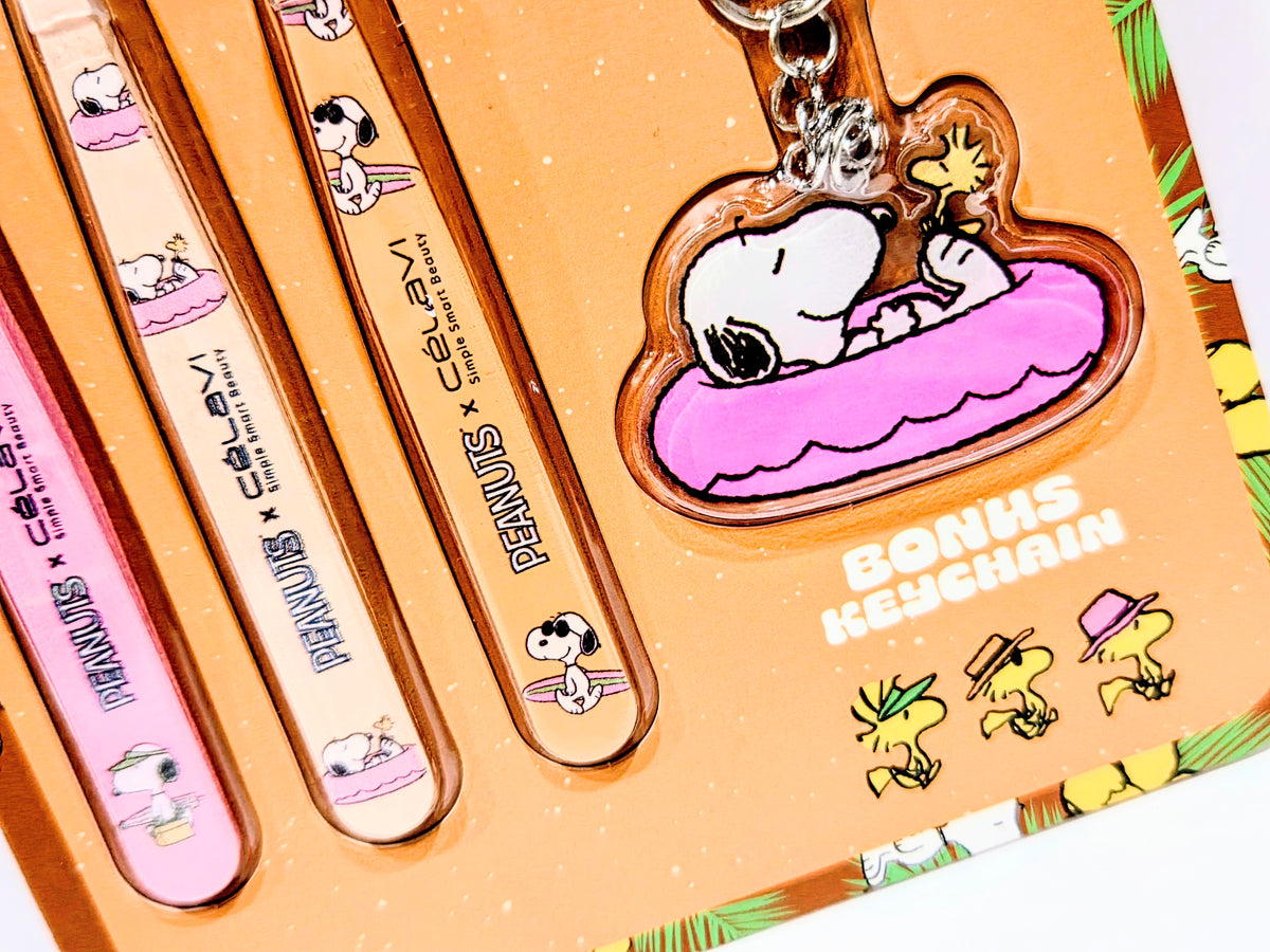 Plastic blister pack with three illustrated tweezers and Snoopy heart keychain charm.
