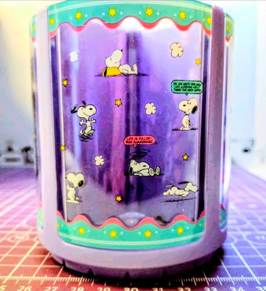 Purple acrylic Peanuts spinning pen holder with multiple Snoopy scenes on panel