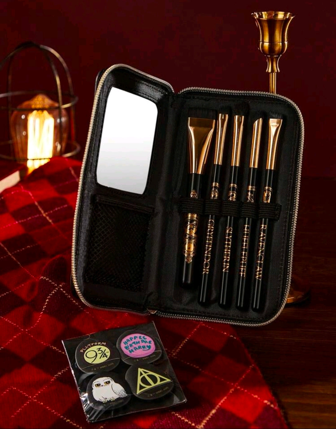 Closed black zippered makeup brush kit with mirror panel and gold brushes, with house charms