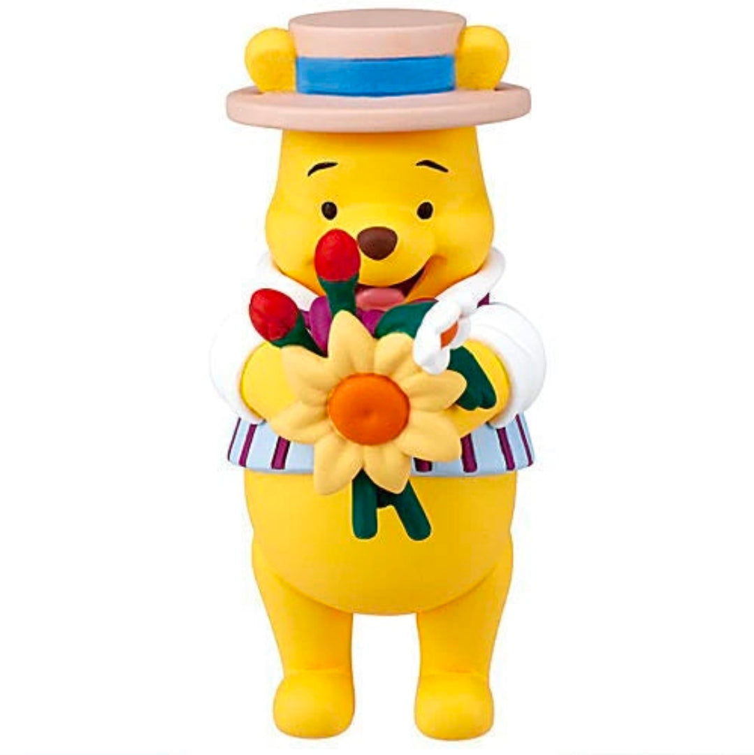 Winnie the Pooh character figure wearing pink top hat and holding a flower bouquet