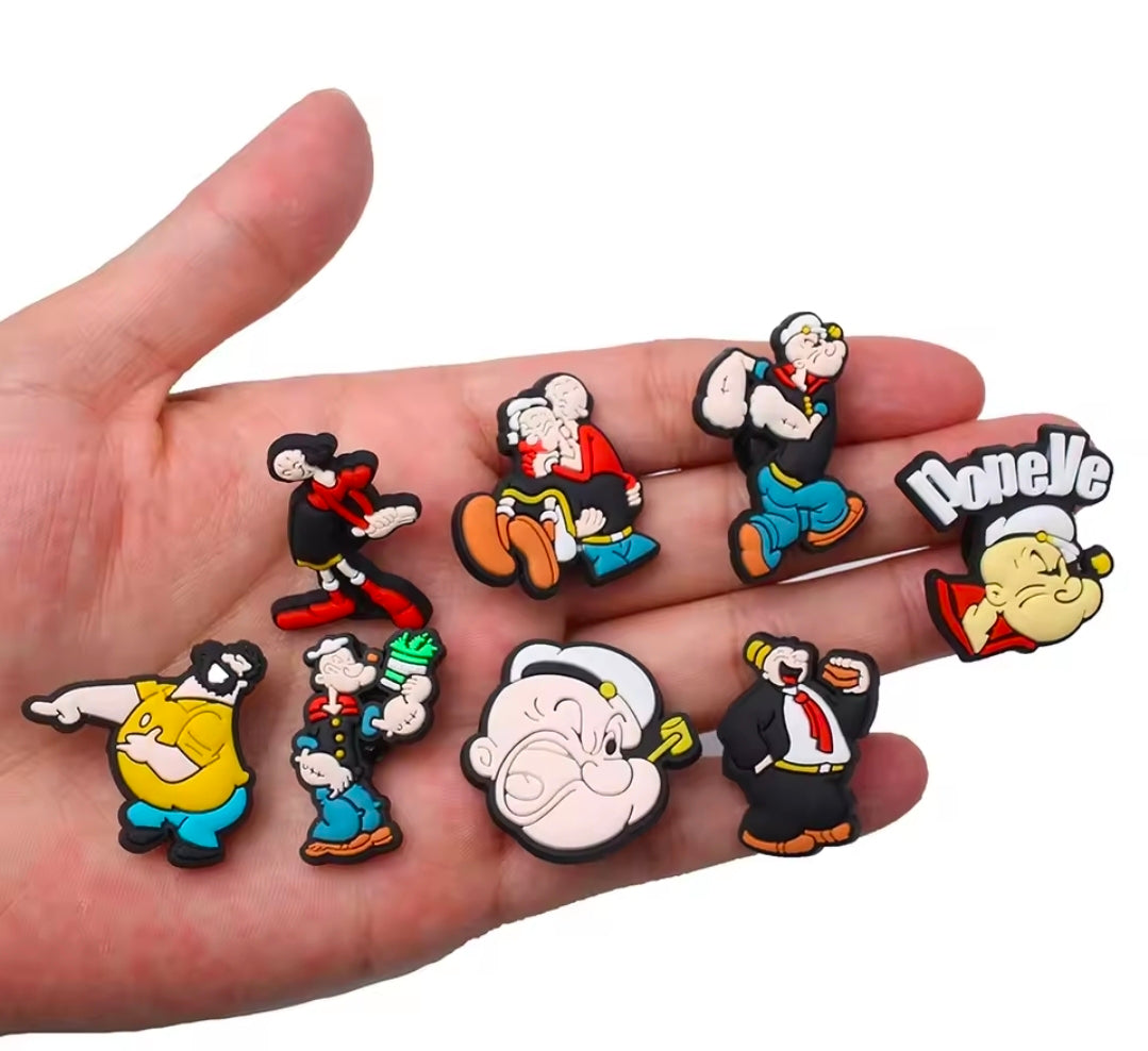 PVC shoe bag charm set on an open hand, featuring several Popeye characters