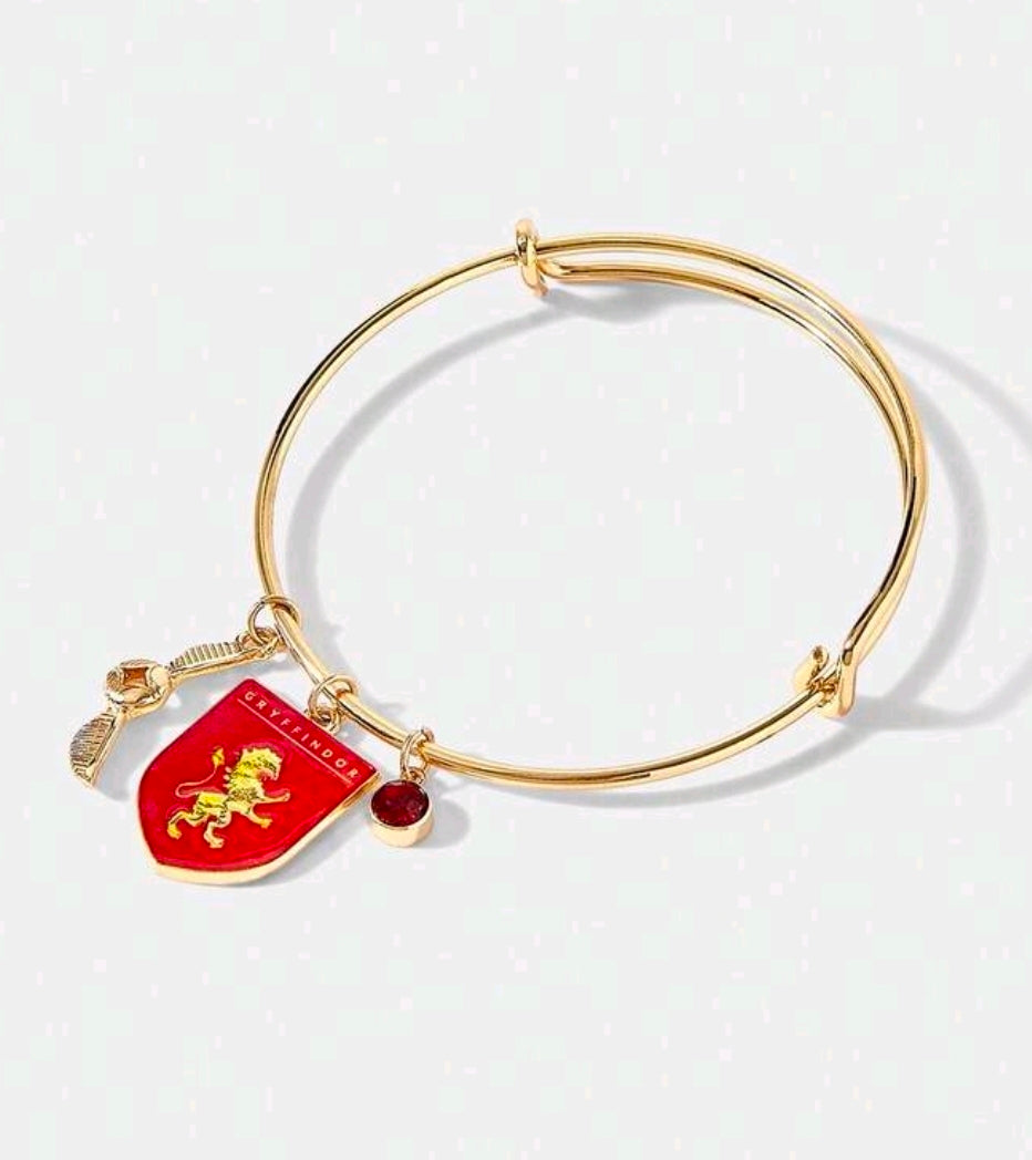Gold-tone charm bangle with Gryffindor red shield charm and small round red bead