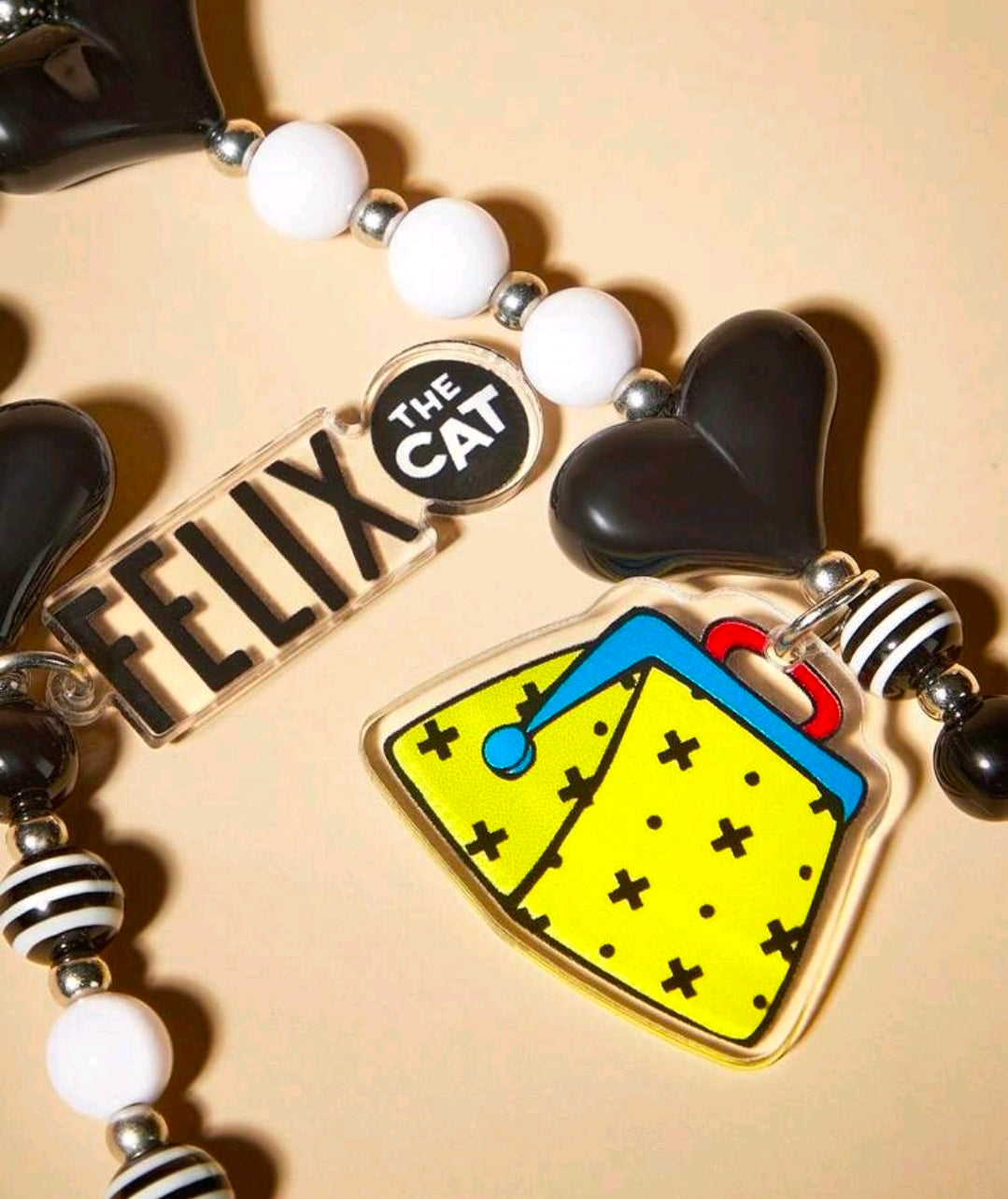Black and white beaded phone charm lanyard with Felix tag, heart charm, striped beads