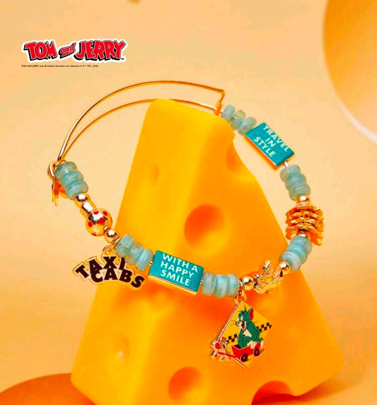 Gold-tone teal bead bangle bracelet with travel bottle, happy smile tag, and cartoon scene charm