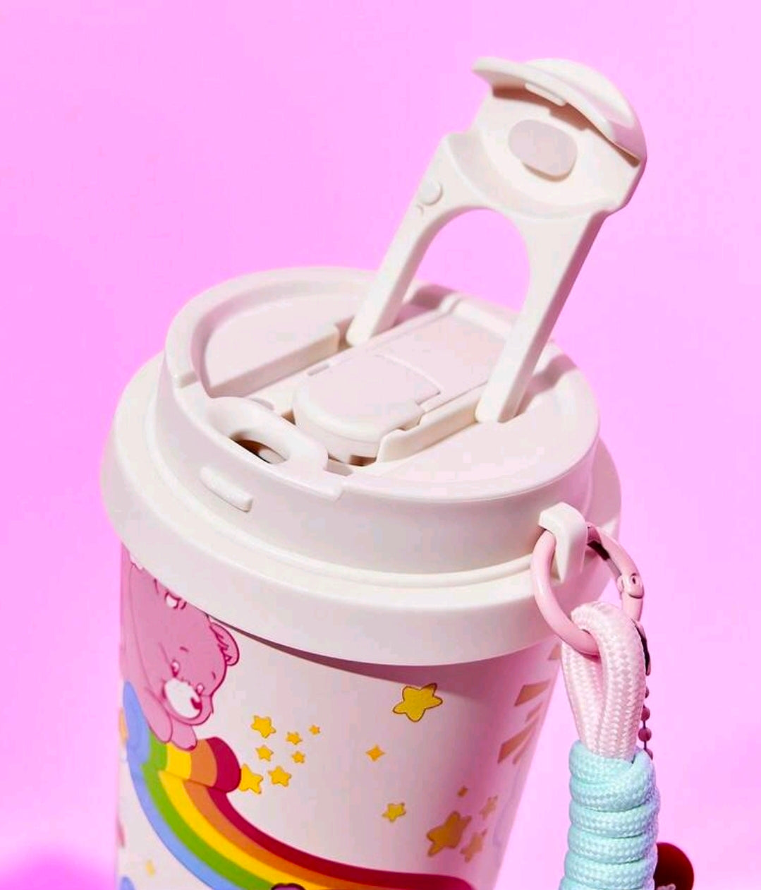 White Care Bears tumbler with open lid and pink wrist strap, light blue cord detail