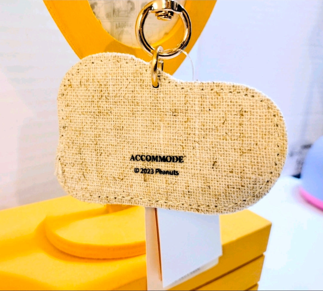 Beige fabric keychain pouch with metal ring clasp, Snoopy side facing