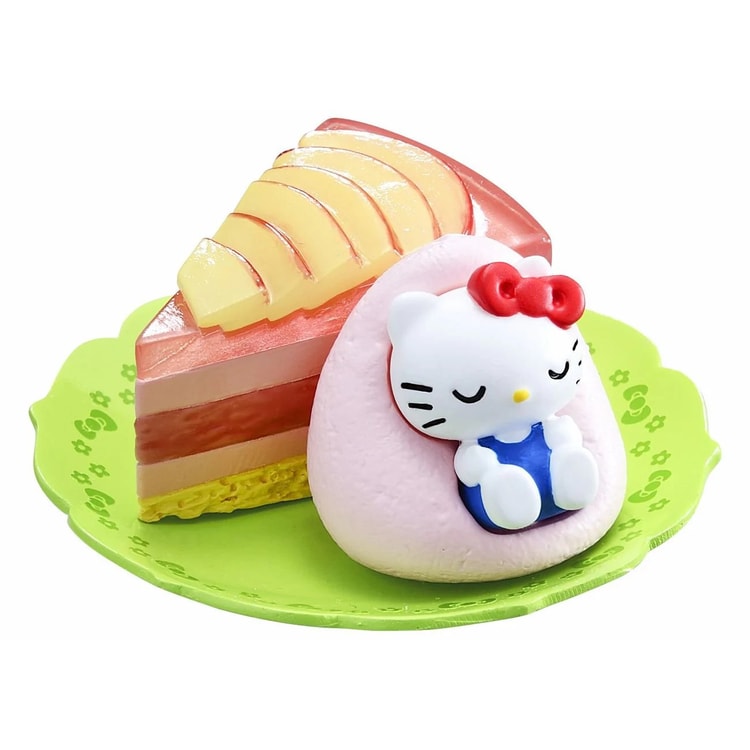 Hello Kitty mousse cake figure with apple slice and white cat face on green plate