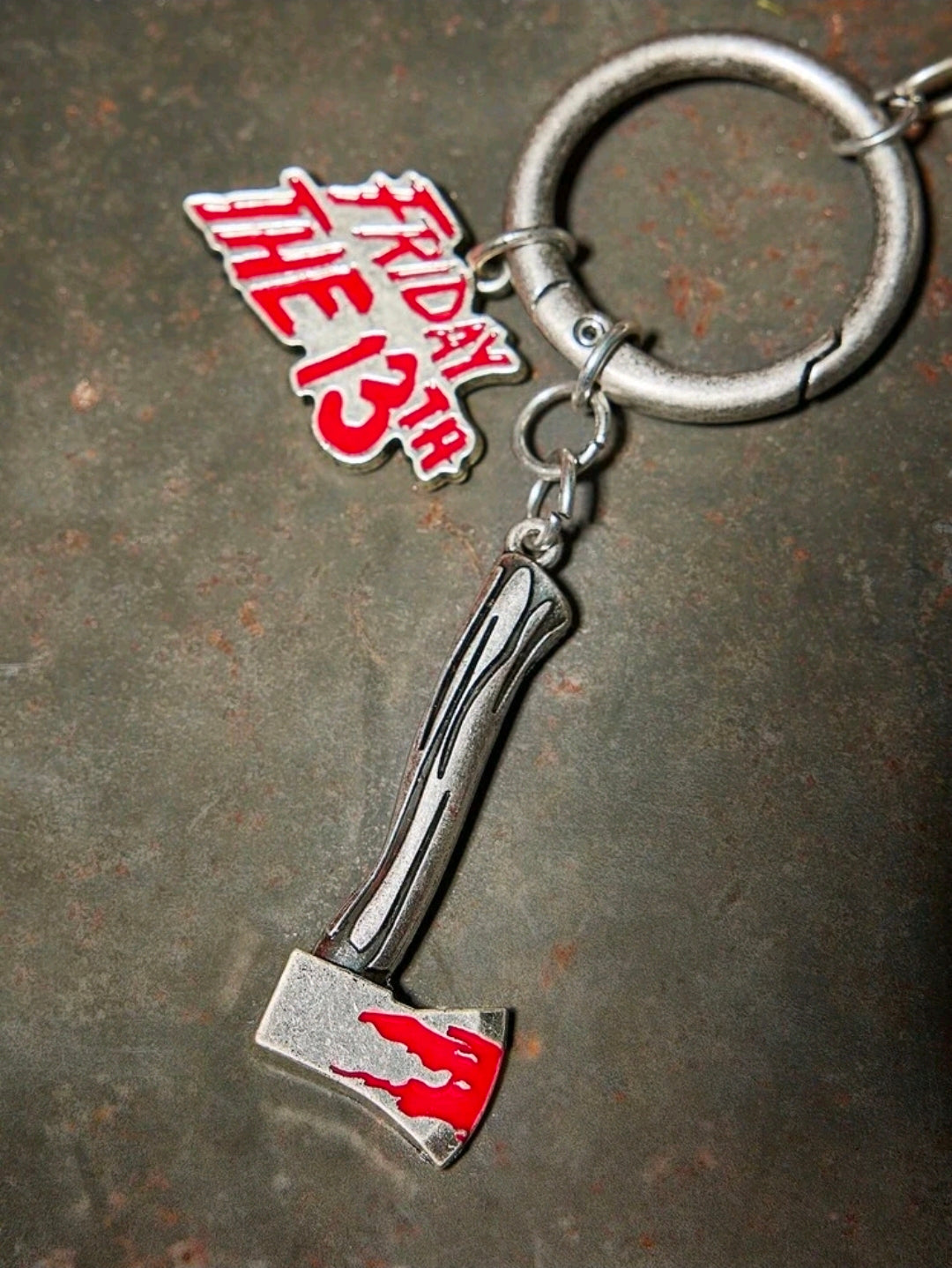 Keychain set with hockey mask charm and axe-shaped metal charm on ring