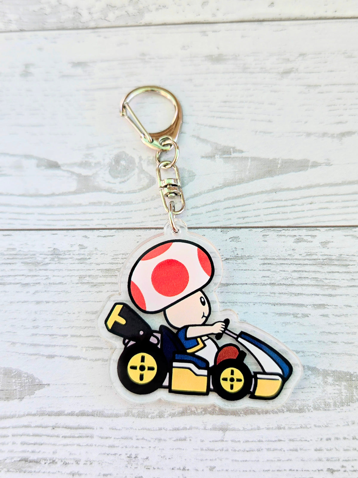Acrylic die-cut keychain of Toad in a kart with gold keyring and ring clip