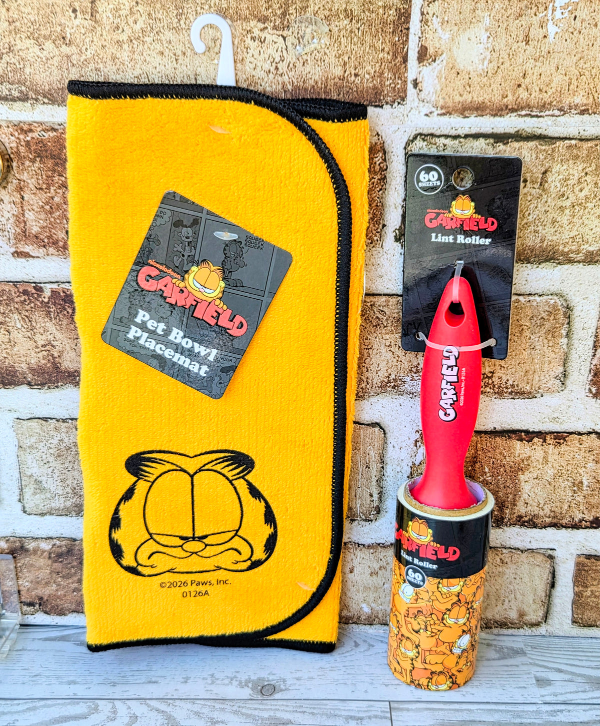 Yellow pet bowl accessory pouch with Garfield logo and red lint roller.
