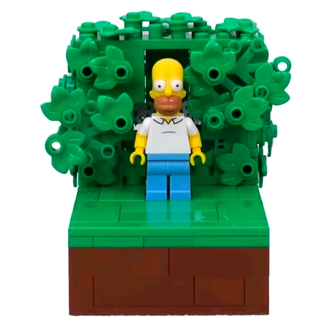 Homer-style minifigure standing in front of dark green foliage canopy on brown base.