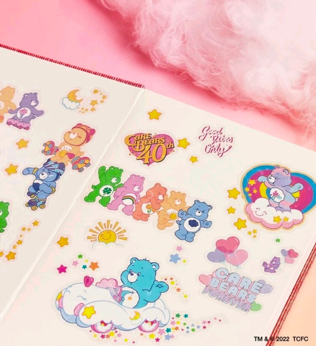 Clear holographic sticker sheet featuring green, pink and blue bears, sunburst and heart icons