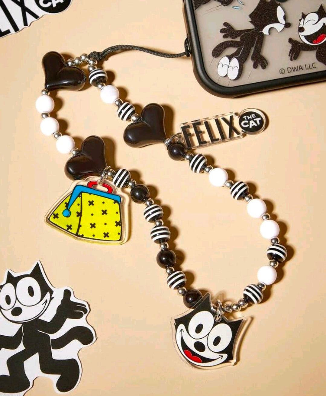 Black and white beaded phone lanyard with Felix face charm and yellow accessory charm
