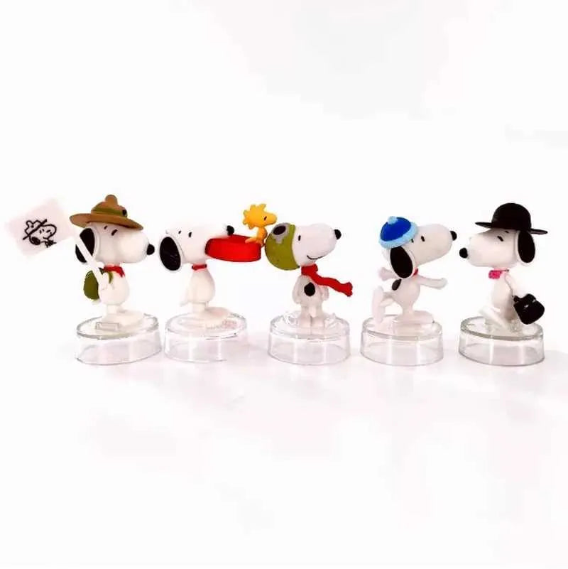 Five Snoopy character figures on clear round bases, each with a different costume detail