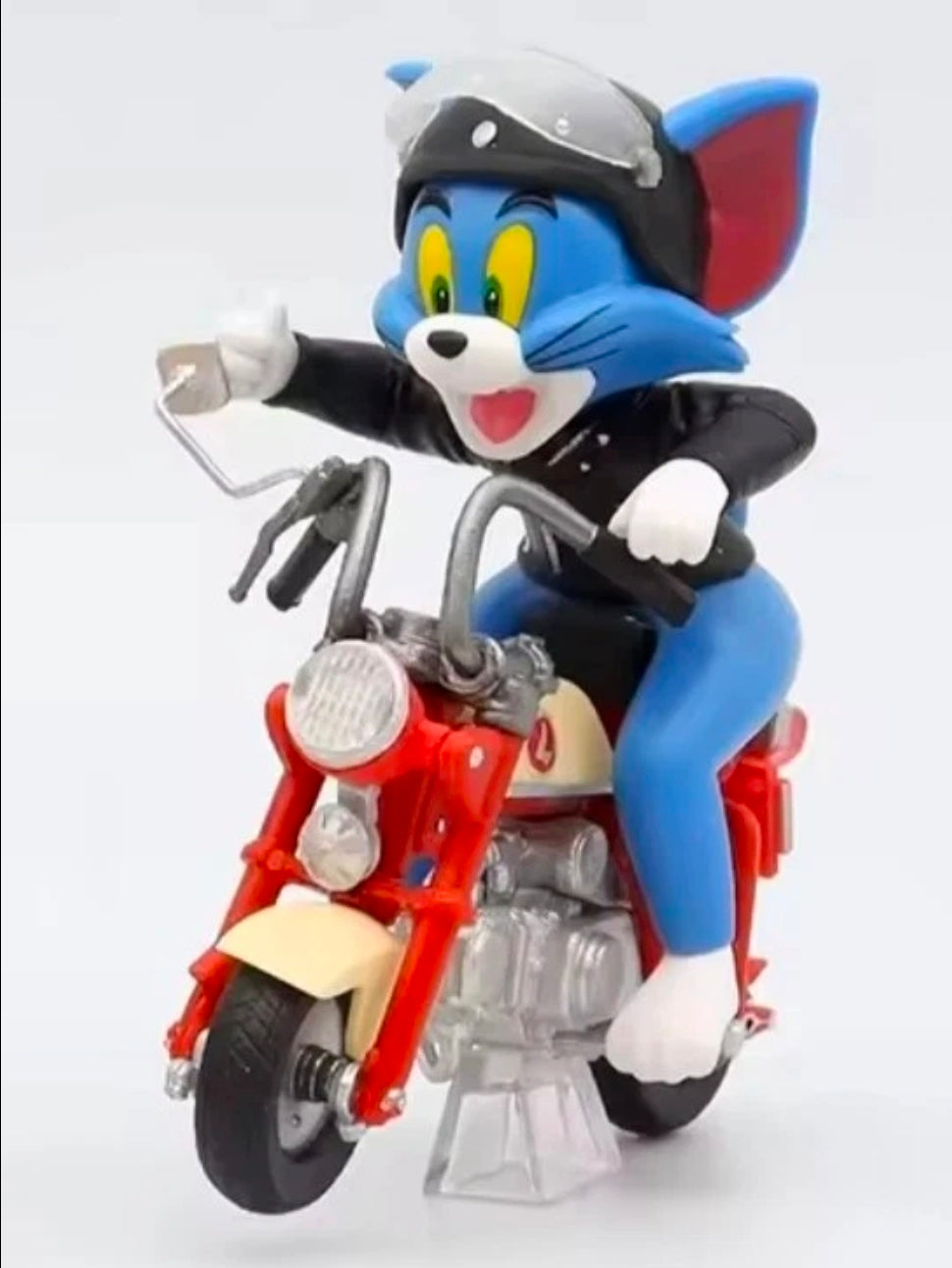 Biker Tom figure on red motorcycle, blue character with open pose and raised arm