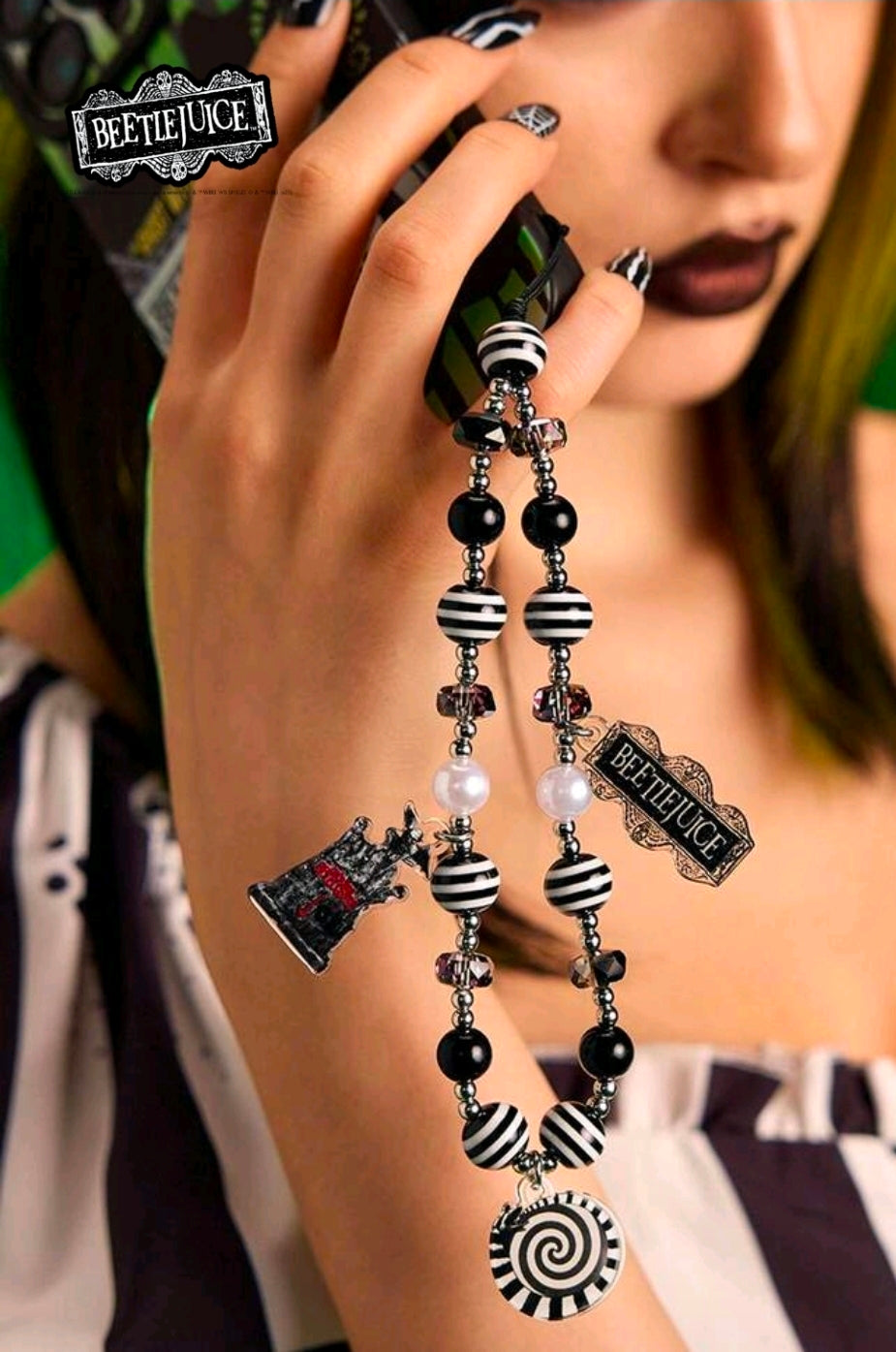 Beetlejuice beaded phone lanyard worn with striped beads, dangling charms, and spiral pendant