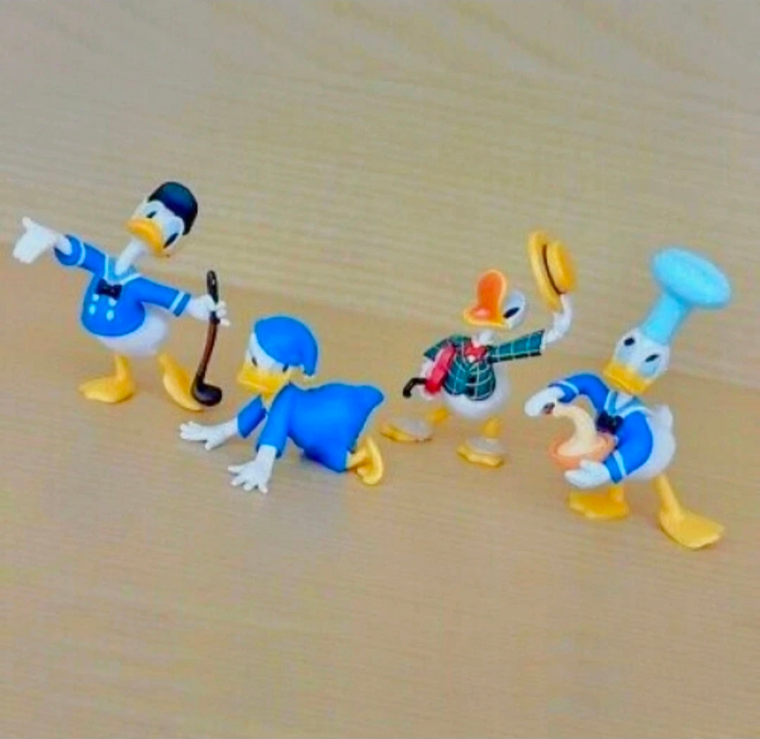 Set of 4 Donald Duck costume figures in blue outfits, assorted poses on a light floor