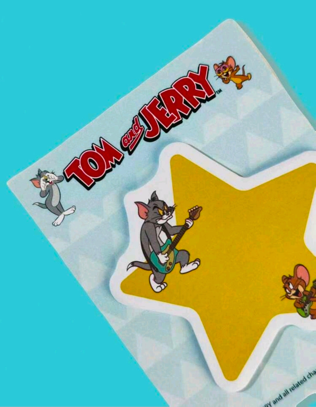 Close-up of yellow star-shaped Tom and Jerry sticky notes in a clear backing