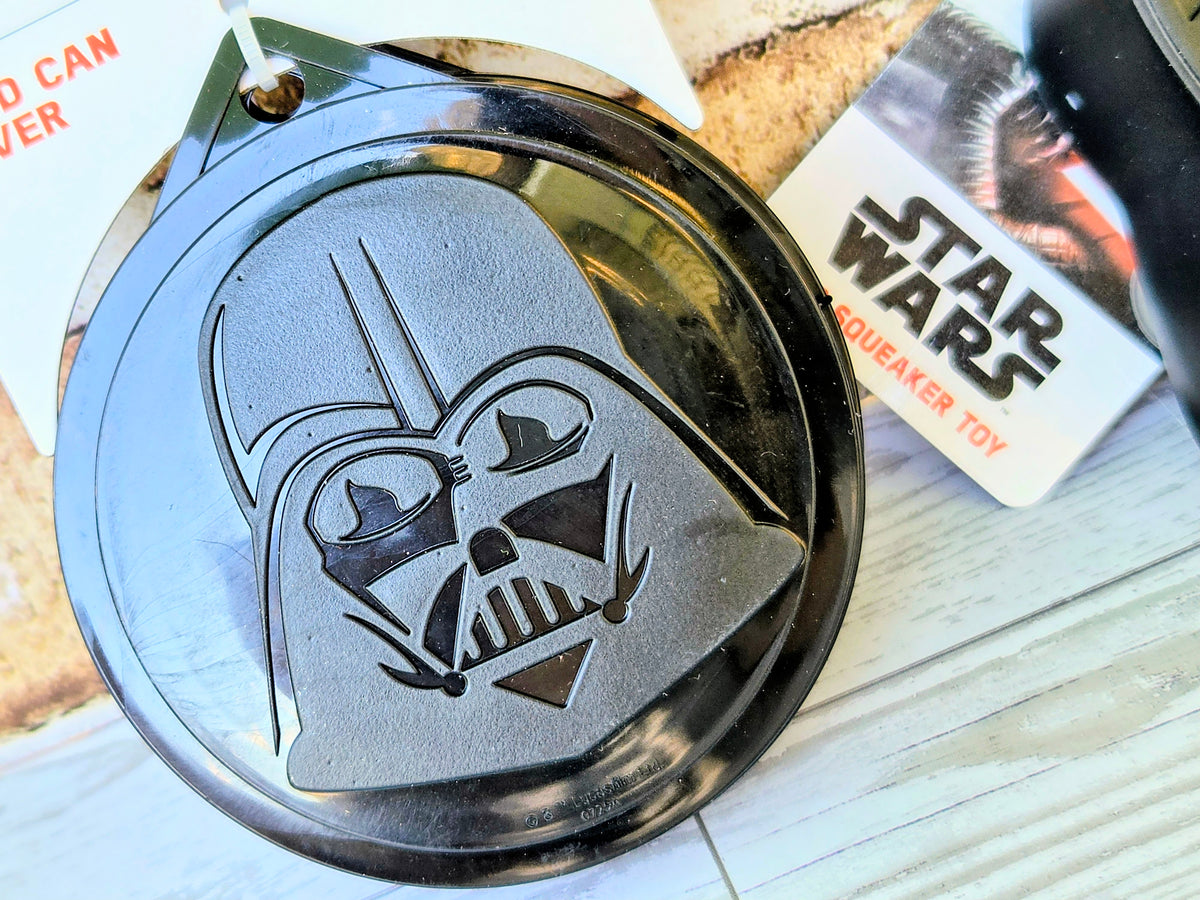 Star Wars squeaker toy with Darth Vader face embossing on round body