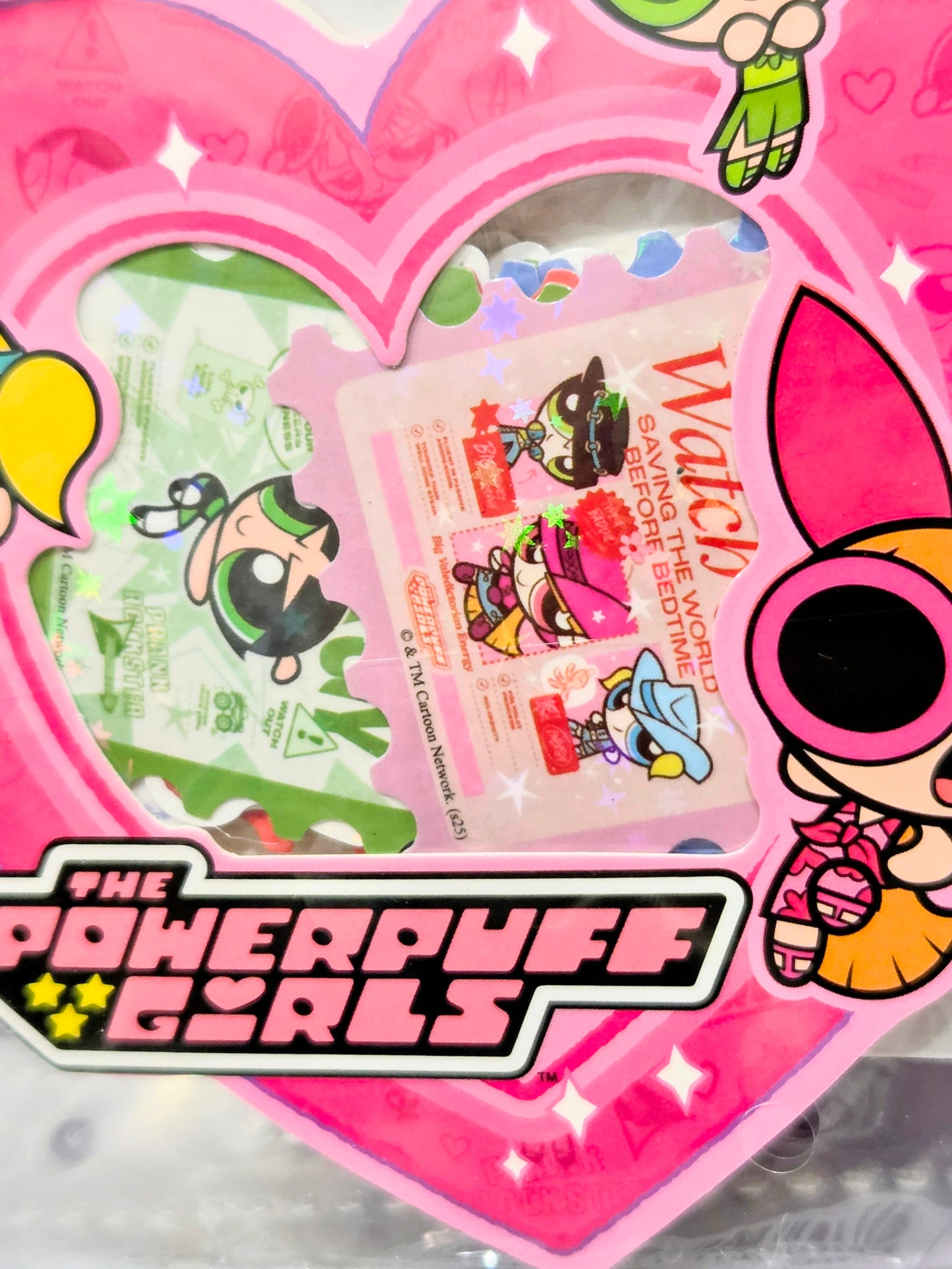 Holographic glitter sticker with pink heart border featuring cartoon characters and logo