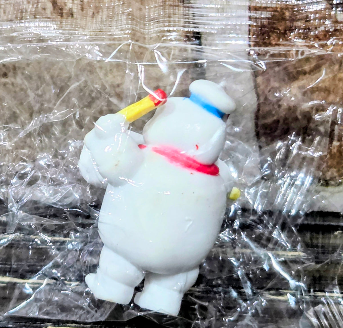 White ghost figure in clear plastic bag holding yellow and red matchstick pieces