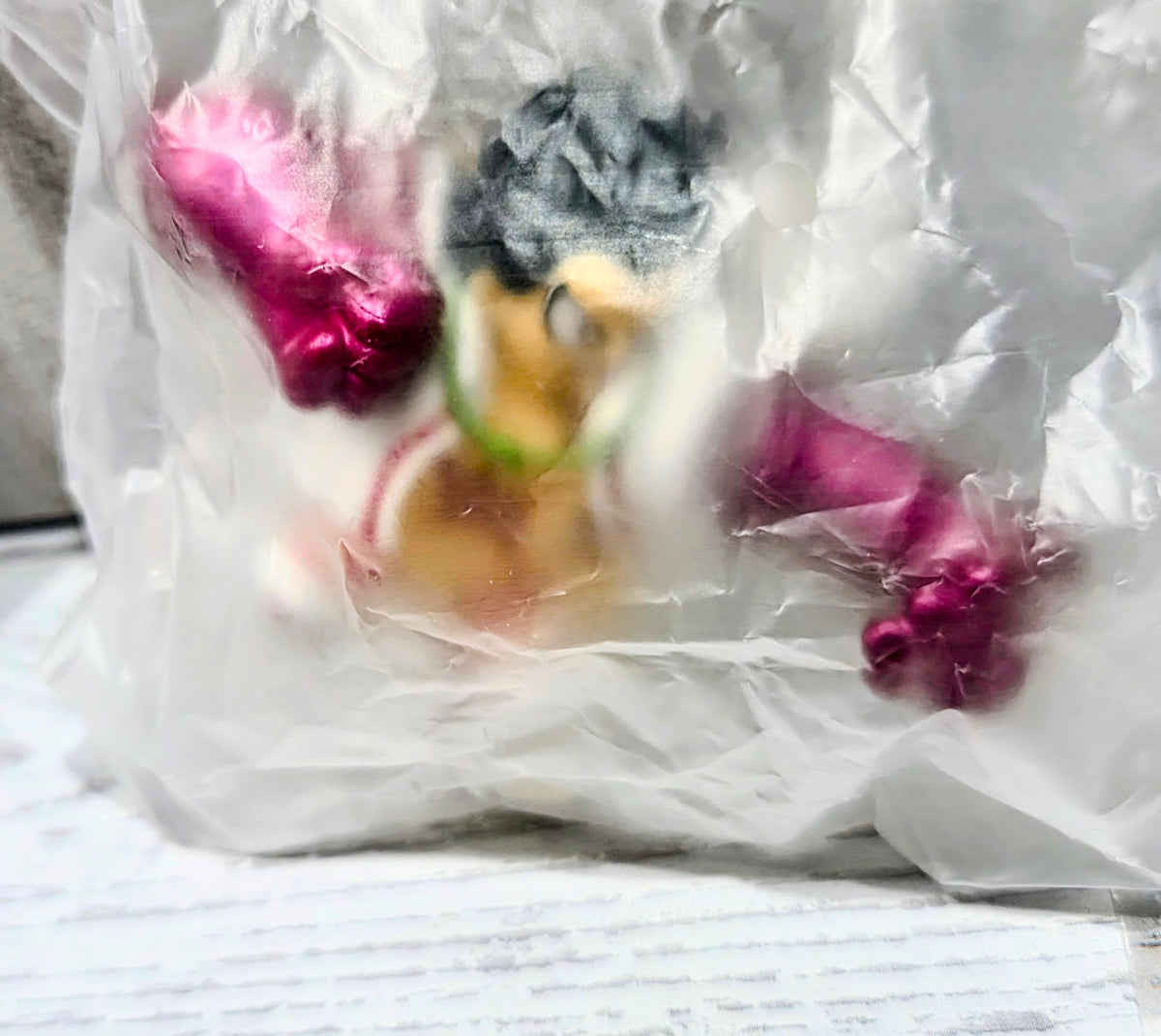 Mini figure parts close-up in a white bag, showing pink boxing gloves and character face.