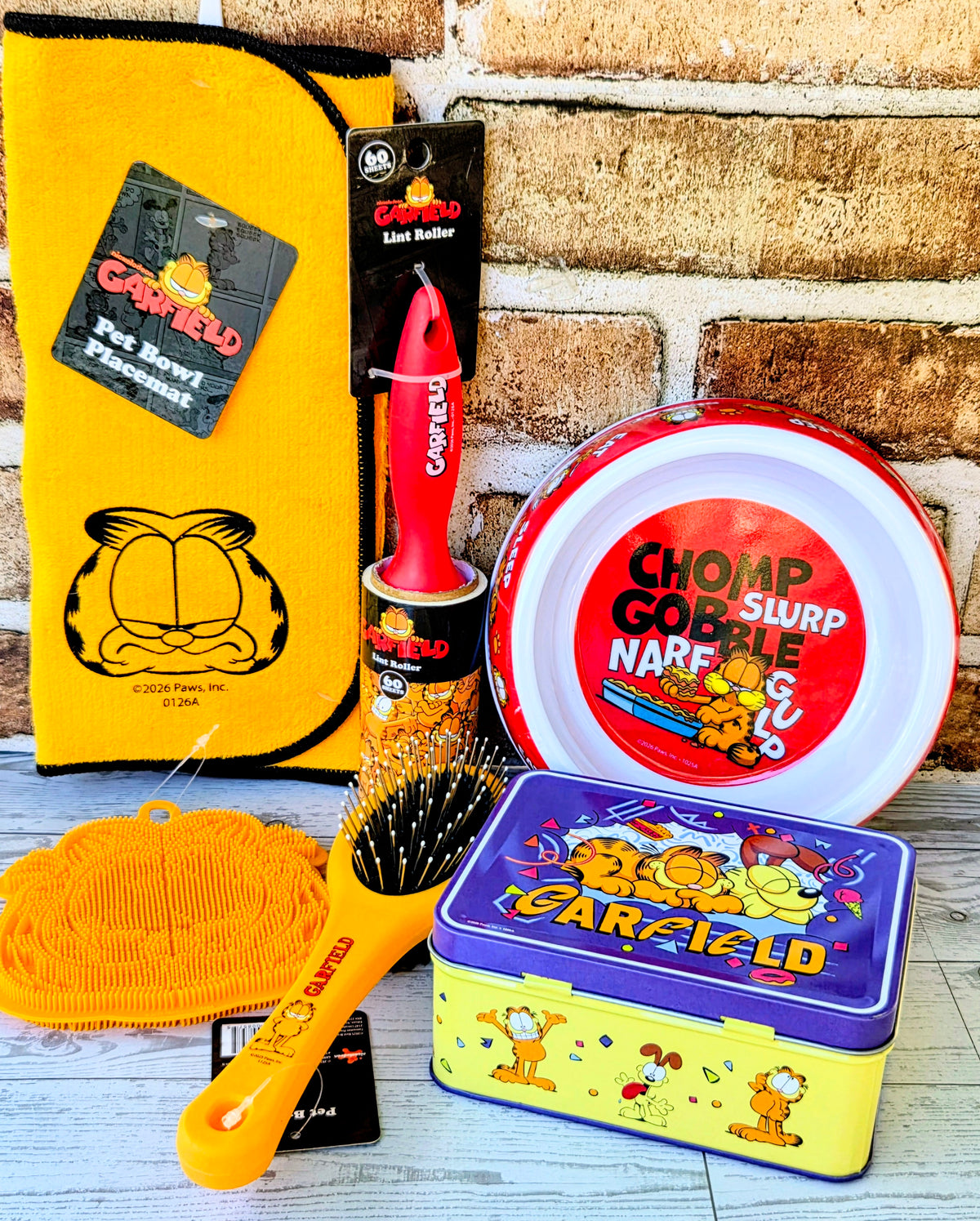 Garfield 6-piece pet gift set with bowl, purple tin, lint roller, brush, and pouches.