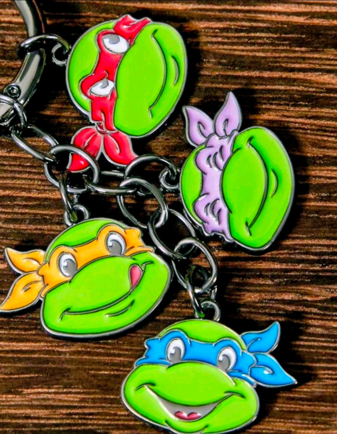 Teenage Mutant Ninja Turtles keychain with four character charm faces on rings