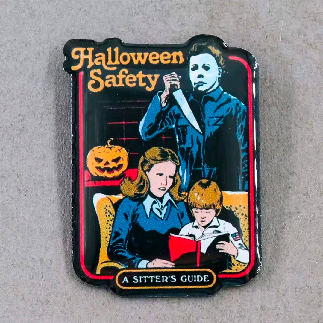 Halloween Safety enamel pin with Michael Myers scene and "A Sitter's Guide"