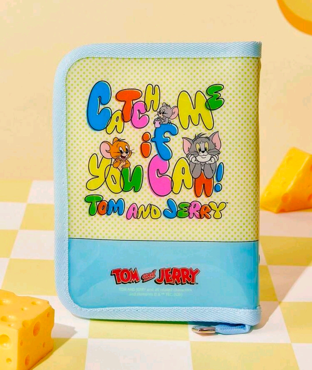 Light blue dotted zipper planner binder with Tom and Jerry graphic stripe and logo.
