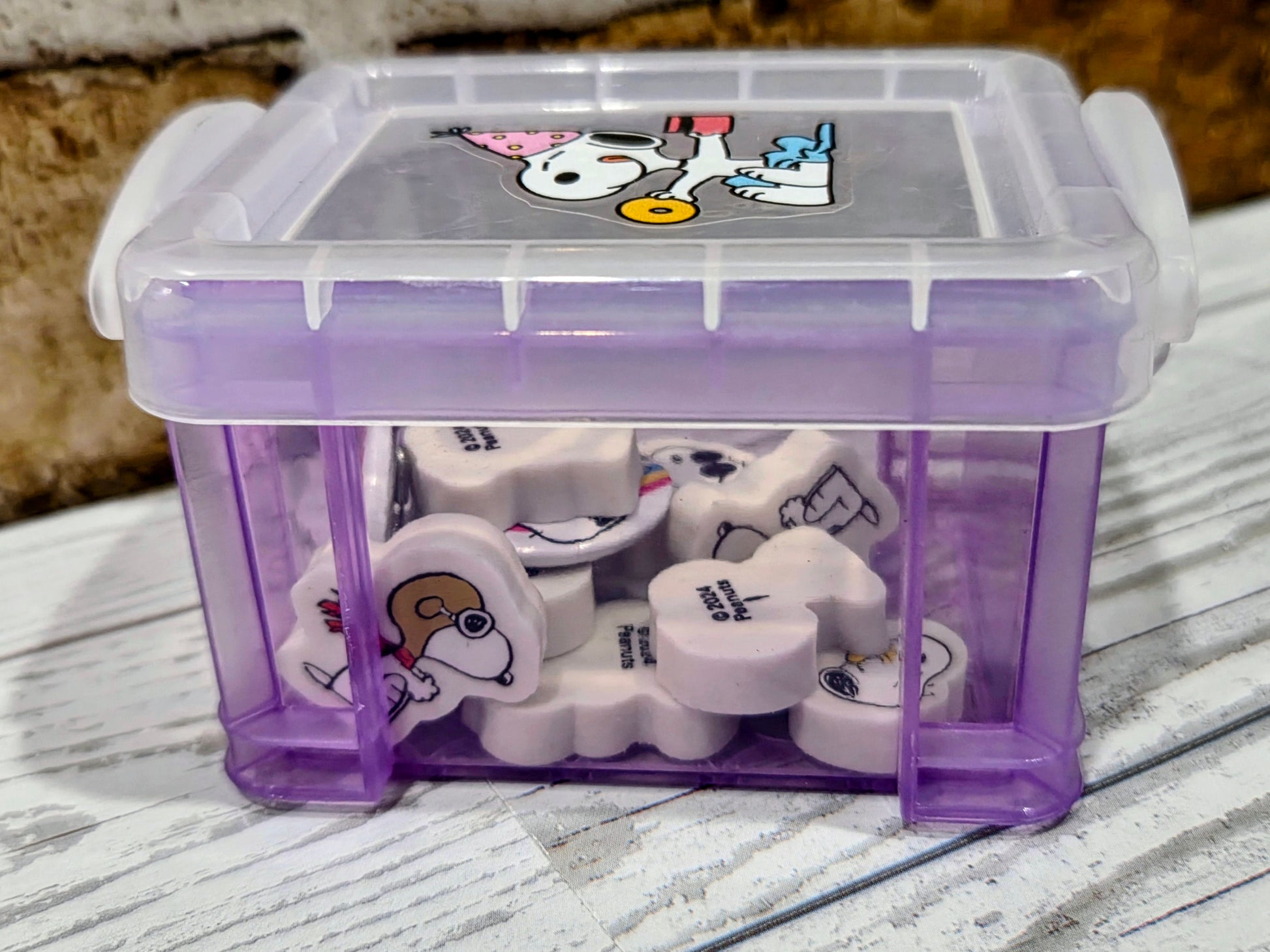 Mini purple desktop organizer box opened, showing Snoopy erasers inside
