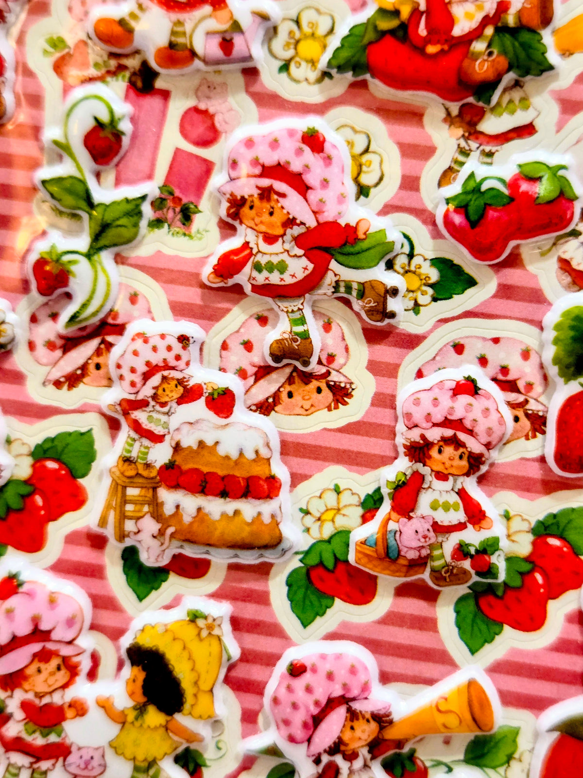 Assorted strawberry dessert character stickers on a pink striped background