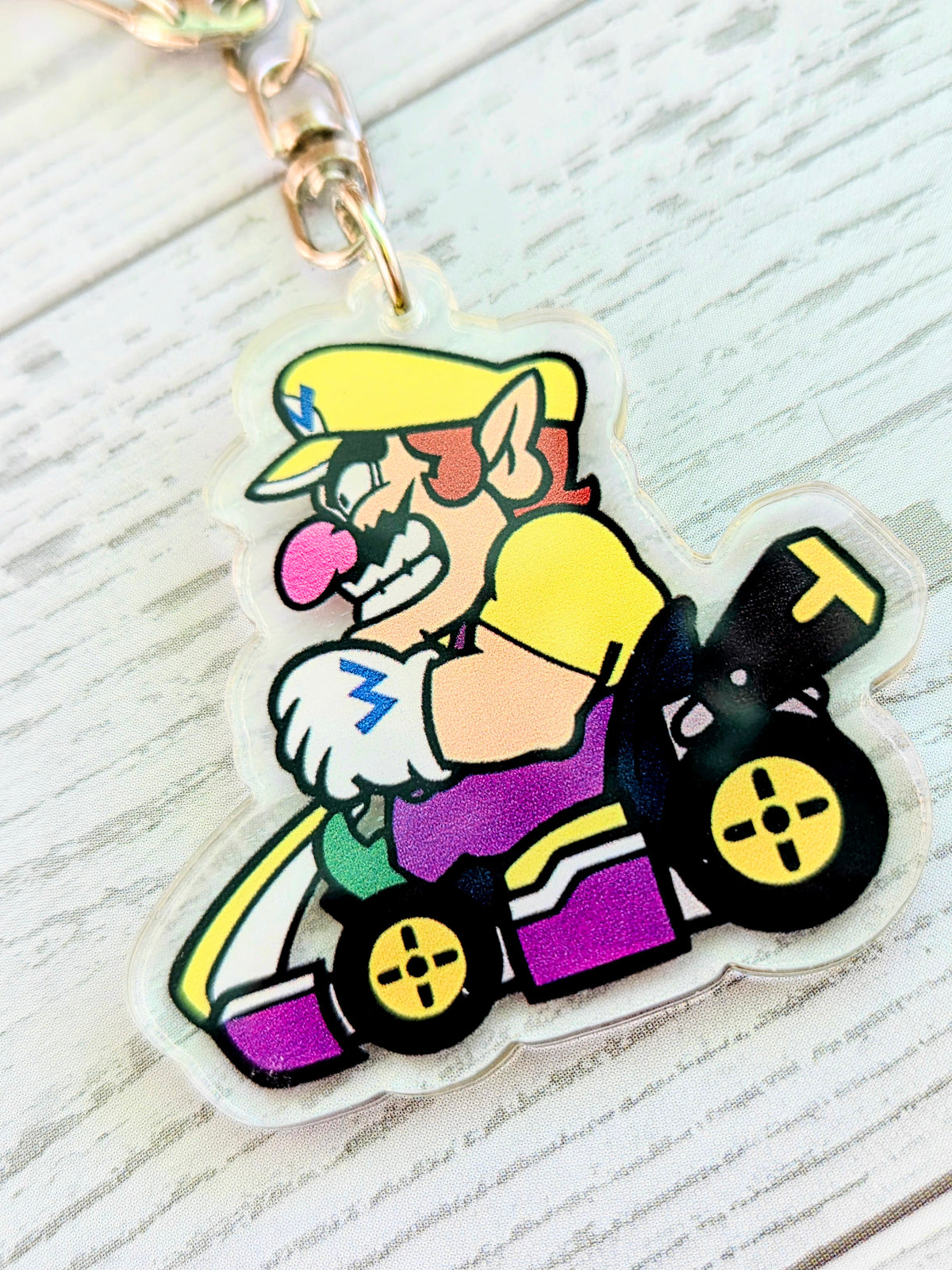 Wario acrylic keychain charm close-up in a purple racing kart