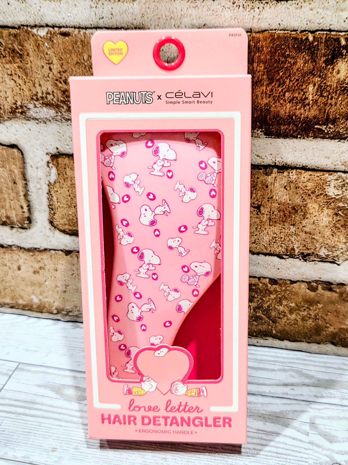 Snoopy-themed pink hair detangler blister package with brush inside