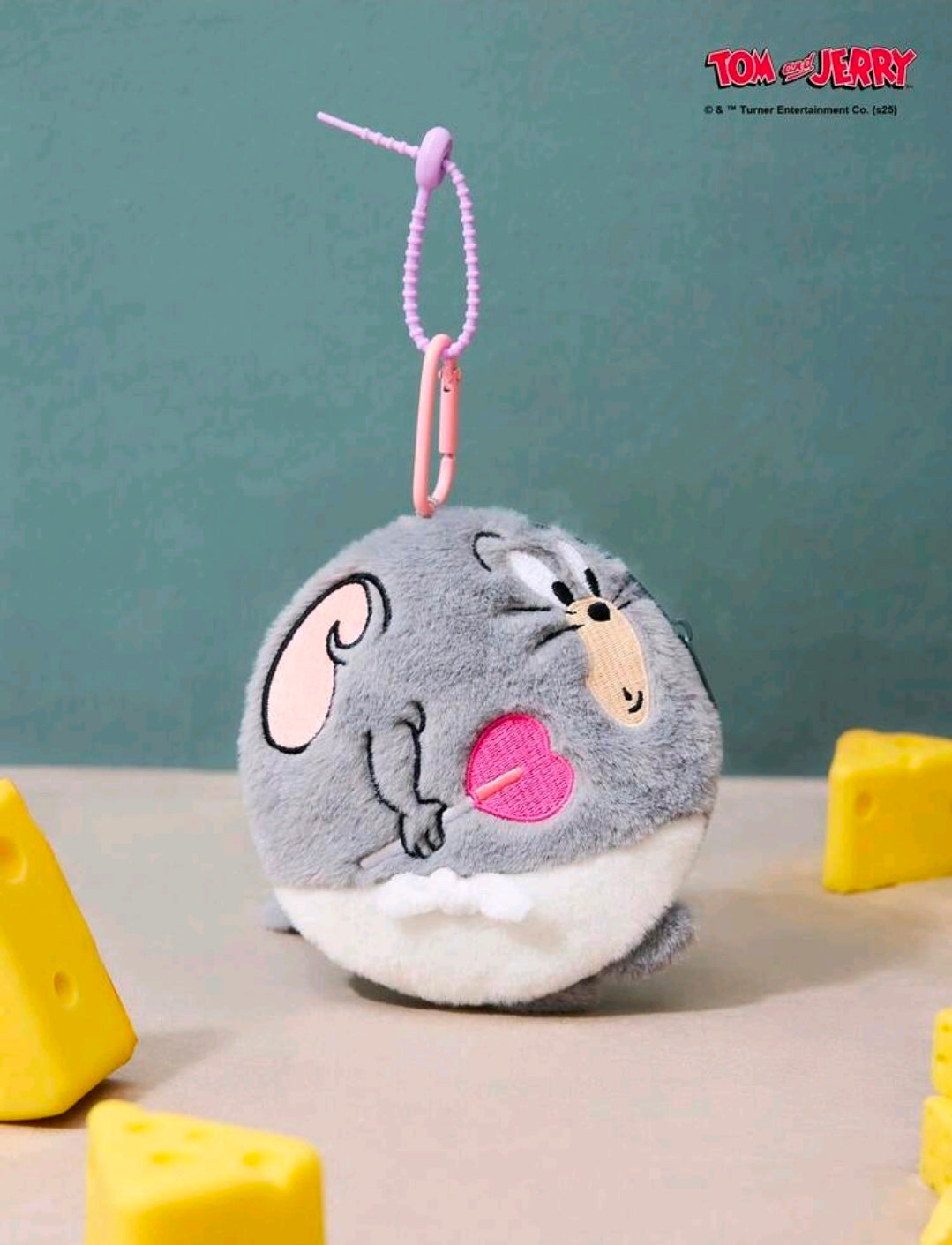 Grey round plush keychain bag charm hanging with pink cord loop and pink heart