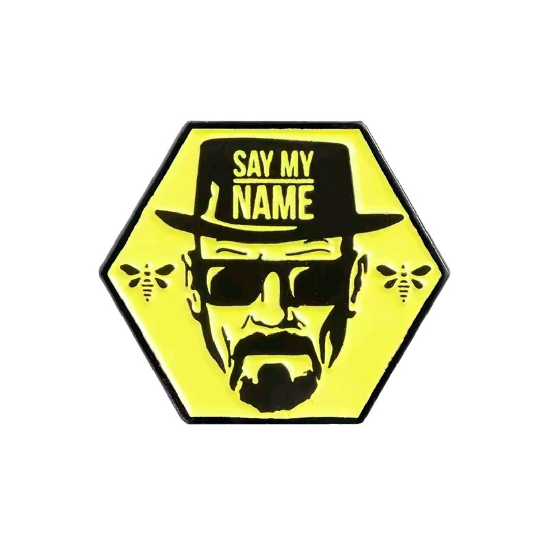Yellow hexagon enamel pin reading “Say My Name” above black portrait