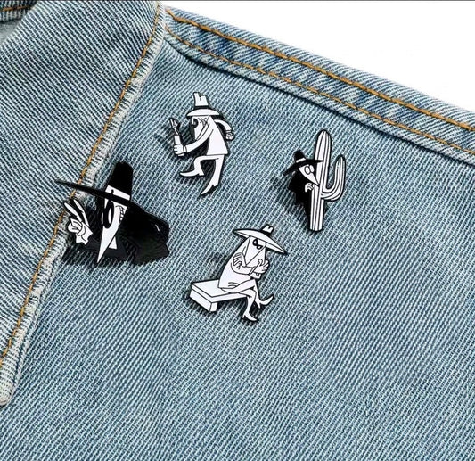 Enamel spy pins on light-blue denim fabric, black-and-white character artwork